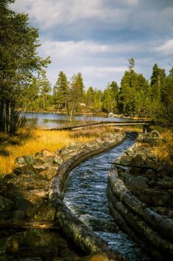 Güzel bir sonbahar sahne kereste göller arasında taşıma için bir tarihi su kanalı. Ahşap inşaat. Sonbahar Femundsmarka Milli Parkı'nda.