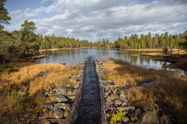 Güzel bir sonbahar sahne kereste göller arasında taşıma için bir tarihi su kanalı. Ahşap inşaat. Sonbahar Femundsmarka Milli Parkı'nda.