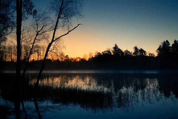Un beau lever de soleil sur un lac avec une brume levante. Belle matinée dans les zones humides en Lettonie. Paysage d'automne aux couleurs vives . — Photo