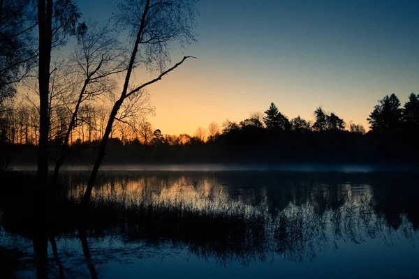 Um belo nascer do sol num lago com uma névoa. Bela manhã em zonas húmidas na Letónia. Paisagem de outono em cores brilhantes . — Fotografia de Stock