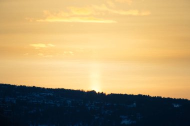 Güzel renkli kış günbatımı Merkez Norveç'te. Dağların üzerinden sıcak akşam ışığı.