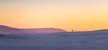 Güzel renkli kış günbatımı Merkez Norveç'te. Dağların üzerinden sıcak akşam ışığı.