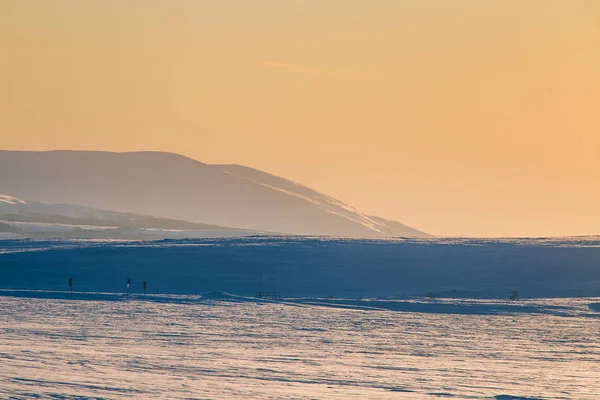 Güzel renkli kış günbatımı Merkez Norveç'te. Dağların üzerinden sıcak akşam ışığı.