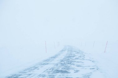 Bir güzel beyaz karlı yol kırmızı Emanet Polonyalılar ile merkez Norveç'te. Minimalist sahne BM Kuzey Avrupa kış.