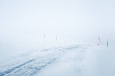 Bir güzel beyaz karlı yol kırmızı Emanet Polonyalılar ile merkez Norveç'te. Minimalist sahne BM Kuzey Avrupa kış.