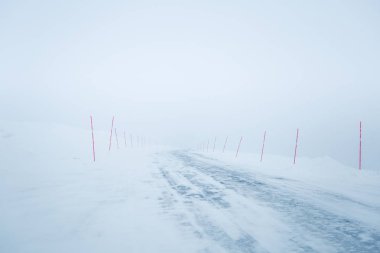 Bir güzel beyaz karlı yol kırmızı Emanet Polonyalılar ile merkez Norveç'te. Minimalist sahne BM Kuzey Avrupa kış.