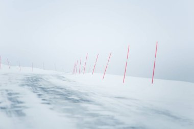 Bir güzel beyaz karlı yol kırmızı Emanet Polonyalılar ile merkez Norveç'te. Minimalist sahne BM Kuzey Avrupa kış.