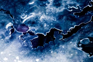 Bir güzel tek renkli closeup kış nehir kıyısında bir buz oluşumları. Mavi arka plan.