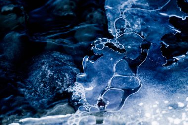 Bir güzel tek renkli closeup kış nehir kıyısında bir buz oluşumları. Mavi arka plan.