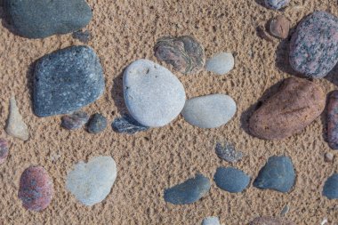 Plajın kumları güzel pürüzsüz deniz taşları. Portre fotoğraf taş dokular ve şekiller.