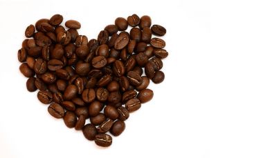 Kahve çekirdekleri beyaz arka plan üzerinde izole oluşan kalp. Kahve sevgisi. Görüntü metni için boş alan ile.