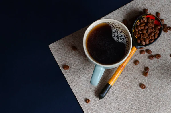 暗い背景に木のスプーンでコーヒー豆とカップで自然なコーヒー Copyspace で描きます トップ ビュー — ストック写真