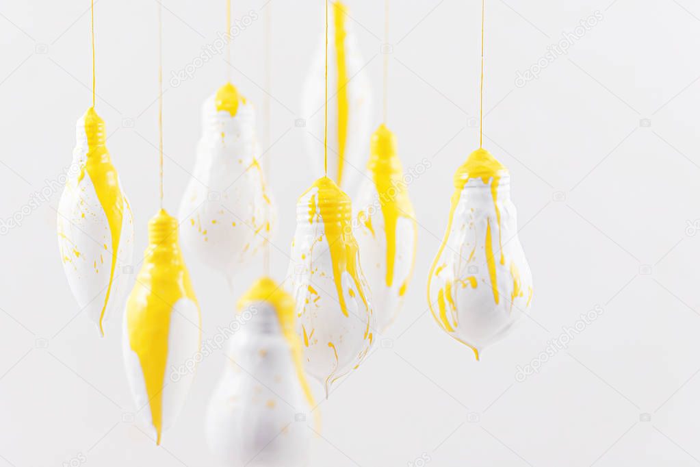 White light bulbs with yellow spray on a white background