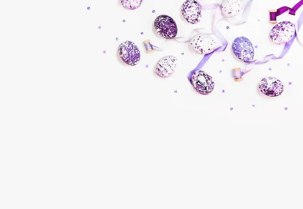 Стильный рамочный фон с пасхальными яйцами и шелковыми лентами. Фиолетовые, сиреневые и белые пасхальные яйца с копировальным местом для текста. Изолированный на белом фоне. Квартира лежала, вид сверху. Пасхальная концепция . — стоковое фото