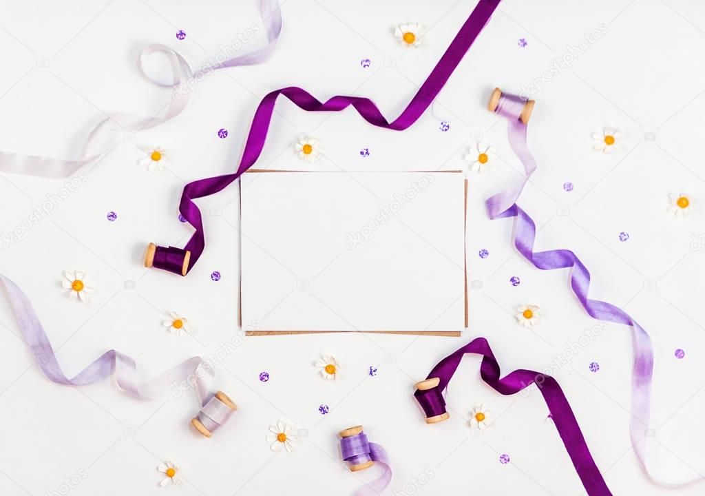 Bright composition with silk ribbons, chamomile, sequins and crystal on a white background. Space for a greeting text. Photos for social media, blogs and web sites. Flat lay, top view.