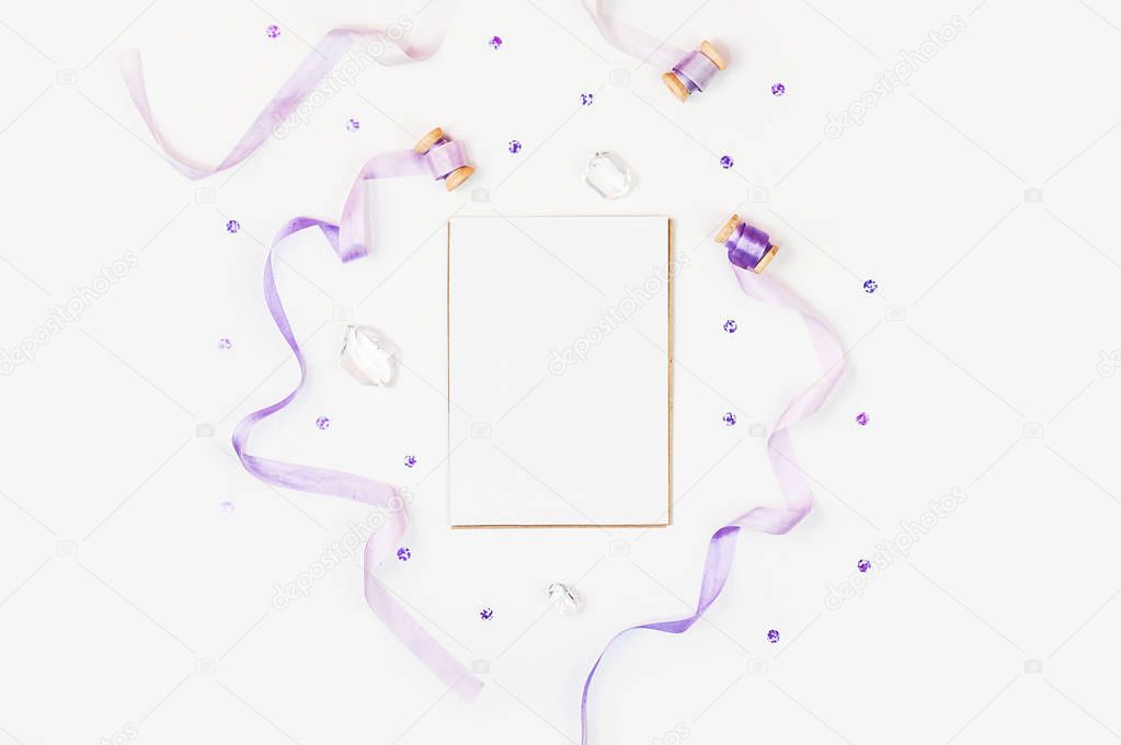 Bright composition with silk ribbons, sequins and crystal on a white background. Space for a greeting text. Photos for social media, blogs and web sites. Flat lay, top view.