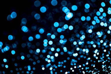 Parlak mavi, ışıltılı, şenlikli bir arka plan. Soyut parıldayan daireler dekoratif arka plan. Parlak efektli Bokeh ışıkları. Üst üste parlayan ve parıldayan noktalar.