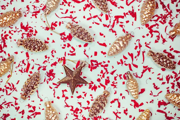 Yeni yıl zarif dekoratif geçmişi. Altın cam köknar ağacı şenlik süsleri. Klasik Xmas kozalakları ve kırmızı kağıt konfetiyle yıldız şeklinde mücevherler. Yatay Noel arkaplanı. — Stok fotoğraf