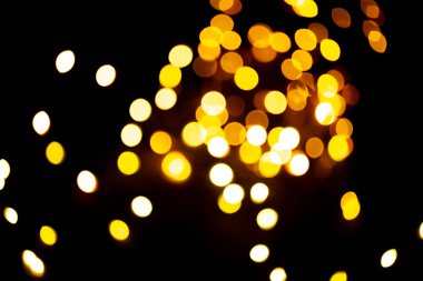 Altın sarısı ışıltılı, şenlikli arka plan. Parlak efekt resimli Bokeh ışıkları. Üst üste parlayan ve parıldayan noktalar dekoratif arka plan. Soyut parlak çemberler.