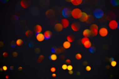 Renkli ışıltılı raster arka planı. Soyut parlak kırmızı daireler koyu mor arka planda. Canlı Bokeh ışıkları, festival illüstrasyonunu etkiler. Üst üste parlayan ve parıldayan noktalar.