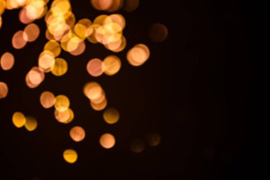 Altın sarısı ışıltılı, şenlikli arka plan. Parlak efekt resimli Bokeh ışıkları. Üst üste parlayan ve parıldayan noktalar dekoratif arka plan. Soyut parlak çemberler