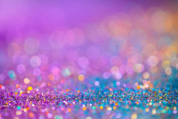Decoration twinkle glitters background, abstract blurred backdrop with circles,modern design overlay with sparkling glimmers. Blue, purple and golden backdrop glittering sparks with glow effect.