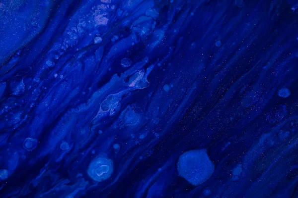 Fluid art texture. Background with abstract swirling paint effect. Liquid acrylic picture with flows and splashes. Classic blue color of the year 2020. Blue, black and white overflowing colors.
