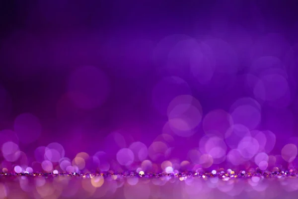 Decoration twinkle lights background, abstract blurred backdrop with circles,modern design wallpaper with sparkling glimmers. Purple, blue and golden backdrop glittering sparks with blur effect.