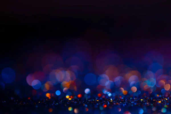 Fondo festivo bokeh brilla, abstracto telón de fondo borroso con círculos, fondo de pantalla de diseño moderno con destellos brillantes. Fondo negro, azul y dorado chispas brillantes con efecto difuminado . — Foto de Stock