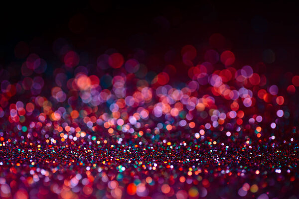 Decoration bokeh glitters background, abstract shiny backdrop with circles,modern design overlay with sparkling glimmers. Black, pink and orange backdrop glittering sparks with glow effect.