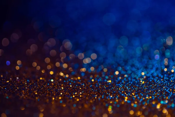 Dekoration bokeh ljus bakgrund, abstrakt glitter bakgrund med cirklar, modern design overlay med gnistrande glimtar. Blå och gyllene bakgrund glittrande gnistor med suddig effekt. — Stockfoto