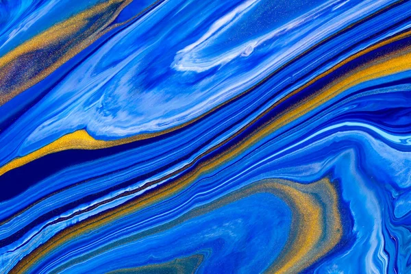 Fluid art texture. Abstract background with mixing paint effect. Liquid acrylic picture with flows and splashes. Classic blue color of the year 2020. Blue, golden and white overflowing colors.