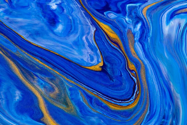 Fluid art texture. Abstract background with iridescent paint effect. Liquid acrylic artwork with artistic mixed paints. Classic blue color of the year 2020. Blue, golden and white overflowing colors.