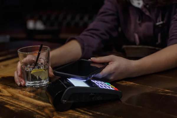 young woman with a credit card in the pub