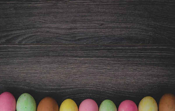 Paskalya kavramı: koyu ahşap arka plan üstten görünüm üzerinde yumurta boyalı