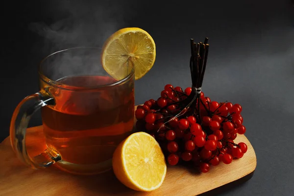 Чашка горячего чая с лимоном и вибурнумом . — стоковое фото