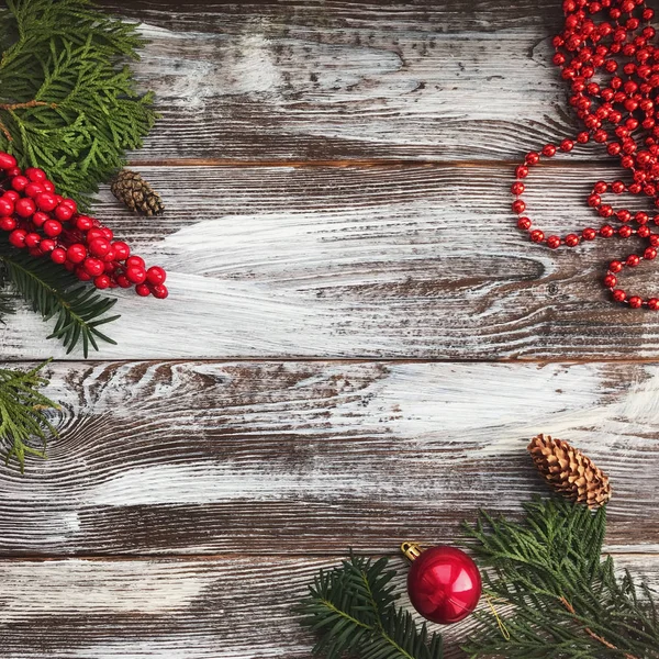 De samenstelling van de kerst met kopie ruimte. Kerst bal en kralen, dennenappels, fir takken op houten achtergrond. Plat lag, top uitzicht — Stockfoto