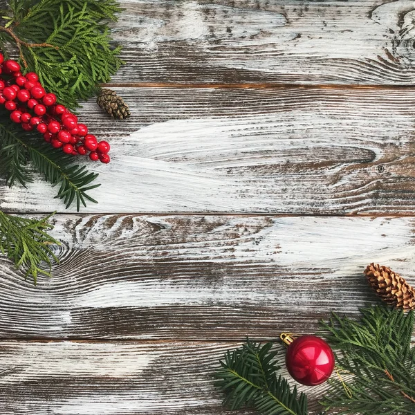 De samenstelling van de kerst met kopie ruimte. Kerst bal, dennenappels, fir takken op houten achtergrond. Plat lag, top uitzicht — Stockfoto