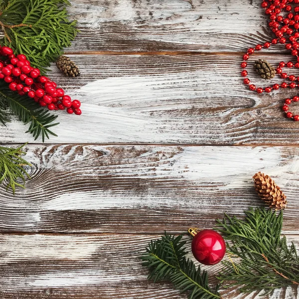 De samenstelling van de kerst met kopie ruimte. Kerst bal en kralen, dennenappels, fir takken op houten achtergrond. Plat lag, top uitzicht — Stockfoto