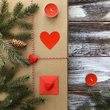 Romantik süslemeleri ile Sevgililer günü kompozisyon: hediye kutusu, mumlar ve kırmızı kalpler ahşap arka plan üzerinde. Kış düz yatıyordu, üstten görünüm. Aşk veya tebrik kavramı. 