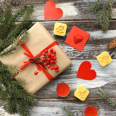 Romantik süslemeleri ile Sevgililer günü kompozisyon: hediye kutusu, mumlar ve kırmızı kalpler ahşap arka plan üzerinde. Kış düz yatıyordu, üstten görünüm. Aşk veya tebrik kavramı. 