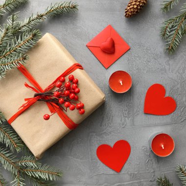 Romantik süslemeleri ile Sevgililer günü kompozisyon: hediye kutusu, mumlar ve kağıt kalpler grunge gri arka plan üzerinde. Kış düz yatıyordu, üstten görünüm. Aşk kavramı. 