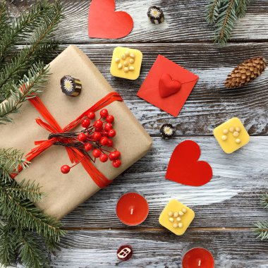 Romantik süslemeleri ile Sevgililer günü kompozisyon: hediye kutusu, mumlar, tatlılar ve kırmızı kalpler ahşap arka plan üzerinde. Kış düz yatıyordu, üstten görünüm. Aşk veya tebrik kavramı. 