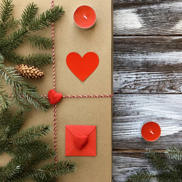 Romantik süslemeleri ile Sevgililer günü kompozisyon: hediye kutusu, mumlar ve kırmızı kalpler ahşap arka plan üzerinde. Kış düz yatıyordu, üstten görünüm. Aşk veya tebrik kavramı. 