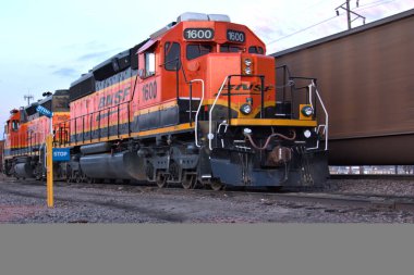 Colorful train engine with another train passing by on the other tracks