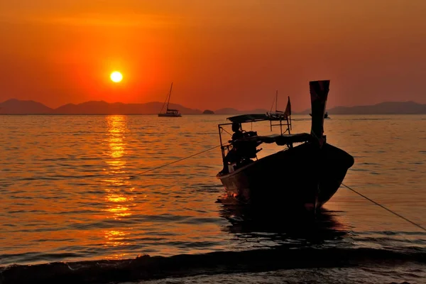 Balıkçı denizden günbatımında döndürür. Railay Beach. 