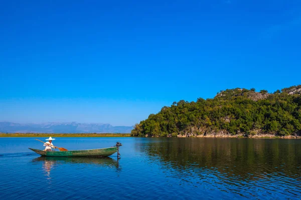 İşkodra Gölü üzerinde bir motor ile bir balıkçı teknesi. Karadağ.