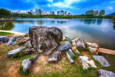 Pitoresk taş şehir binaların zemin karşı parkta gölet önünde. Bailu Park, Sanya, Hainan, Çin.