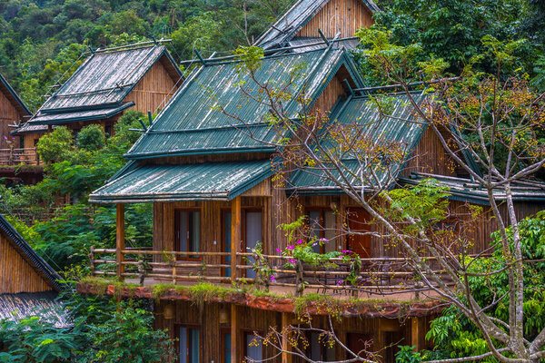 Wooden bamboo houses in the jungle. Sanya Li and Miao Village. Hainan, China.