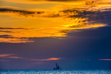 Yüzer petrol platformunda deniz günbatımı. Hainan, Çin.
